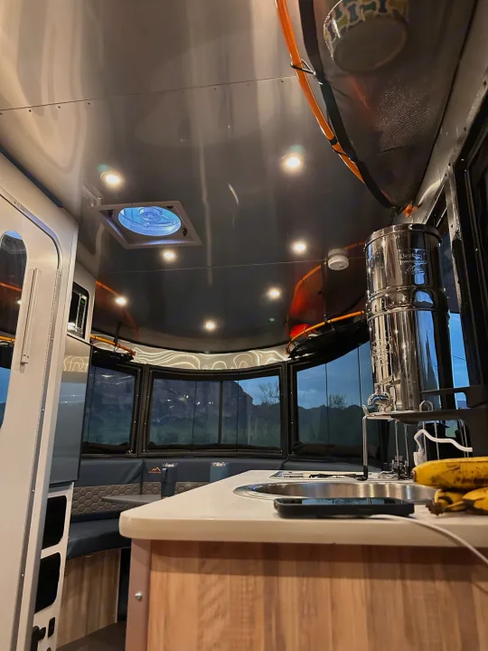 RV rental interior: bright kitchen, dinette, and expansive windows with scenic mountain views.. Airstream Basecamp 2021