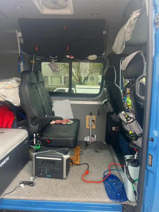 This RV rental showcases a functional camper van interior with flexible seating, portable power, cooler, and water storage solutions.. Mercedes-Benz Sprinter 2021
