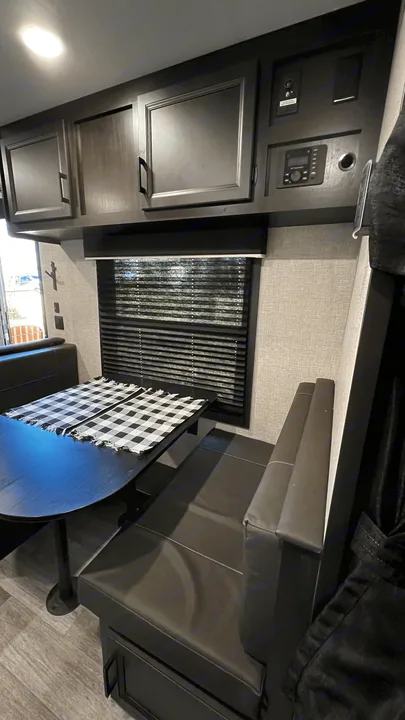 Cozy RV rental dinette area featuring ample storage, a control panel, and large window. Perfect for travel.. Jayco Jay Flight SLX 2022