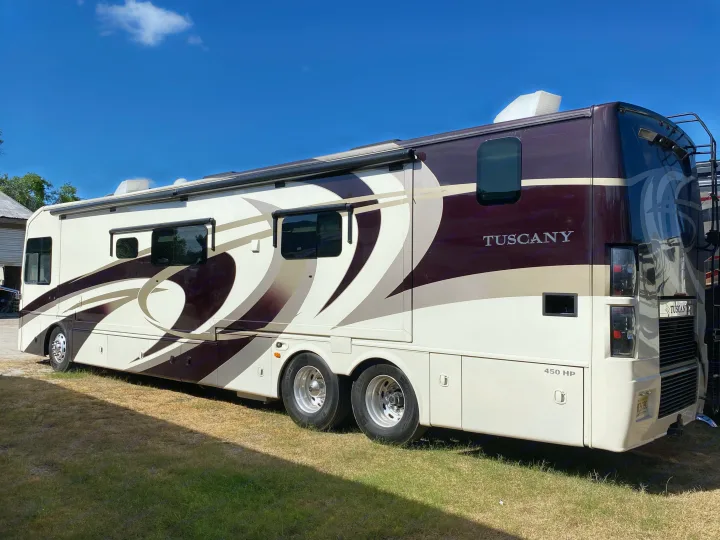 Luxurious cream & burgundy Tuscany rv rental motorhome with 450 HP. Perfect for travel adventures under a blue sky.. Thor Motor Coach Tuscany 2015