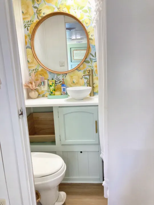Bright RV rental bathroom with yellow floral wallpaper, a stylish vessel sink, and a compact toilet.. Other Other 2013