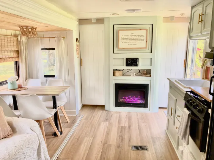 Clean, modern RV rental interior with dining area, cozy seating, and a decorative fireplace for a comfortable stay.. Other Other 2013