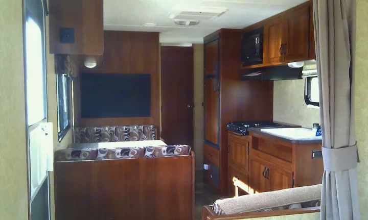 Inside an RV rental: full kitchen with microwave, sink, stove, plus a cozy dinette area.. Avenger LT 2012