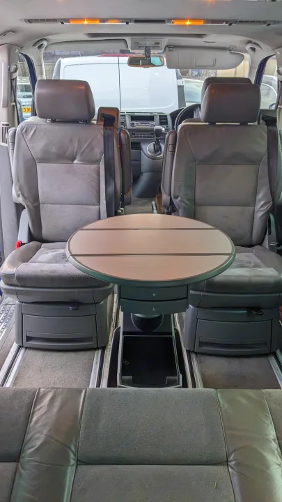 Inside an RV rental, showing swiveling front seats and a central table for a versatile camper van interior. Great for travel.. Volkswagen Other 2006