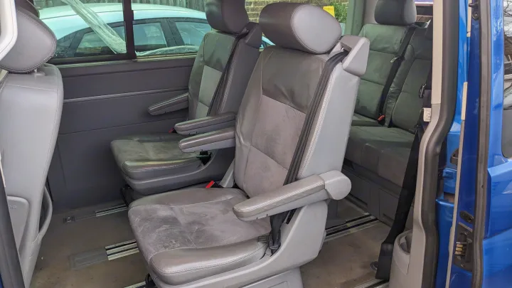 Spacious van interior: adaptable gray seats with armrests on floor rails, great for RV rental.. Volkswagen Other 2006