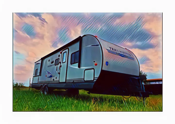 Explore the outdoors! This modern grey travel trailer, perfect for your next RV rental, sits in a lush green field under a vast sky.. Gulf Stream Trailmaster 2020
