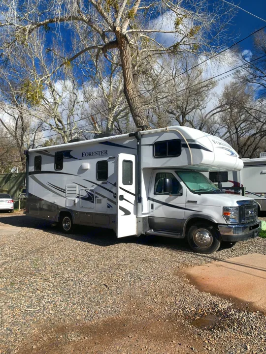 Discover this white Forest River Forester Class C RV, parked on gravel under bare trees – ideal for your next RV rental.. Forest River Other 2018