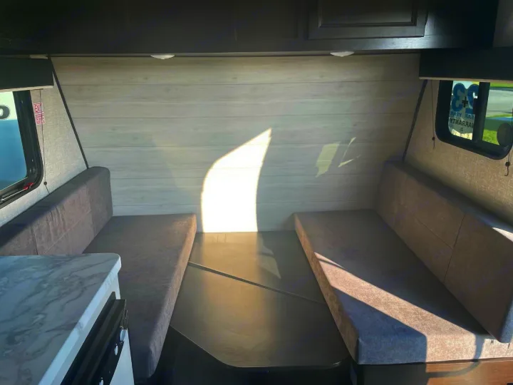 Spacious RV rental interior featuring a convertible dinette with comfy grey seating, perfect for your next camper adventure.. Jayco Jay Flight SLX 2022