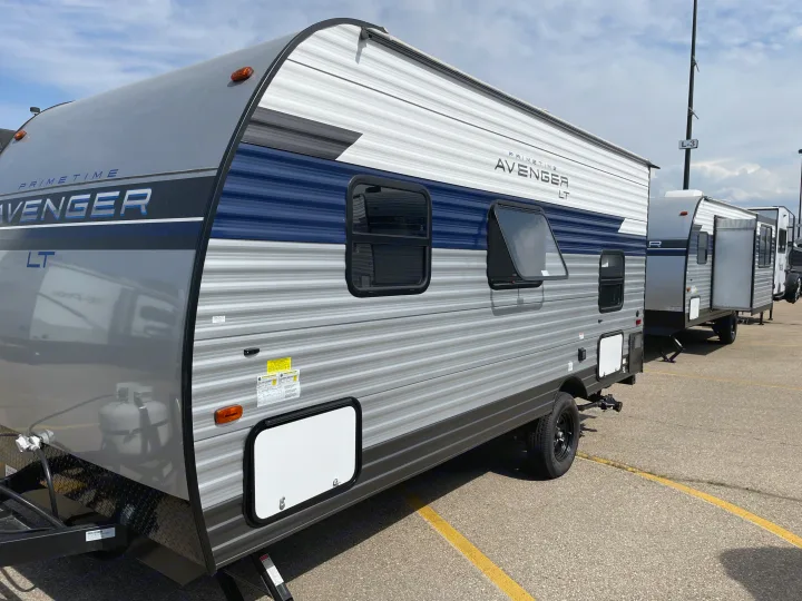 Modern grey and blue Primetime Avenger LT travel trailer, ideal for an RV rental adventure. Parked in an outdoor lot.. Avenger LT 2022