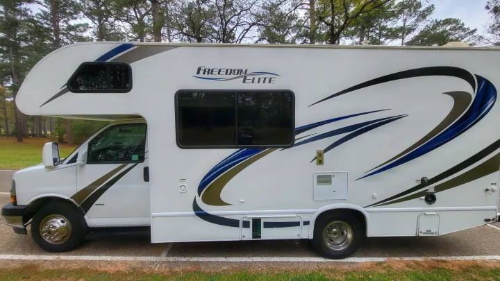 Explore the outdoors with this spacious white Class C motorhome, an ideal rv rental for adventure. Features blue & brown accents.. Thor 22HE 2019