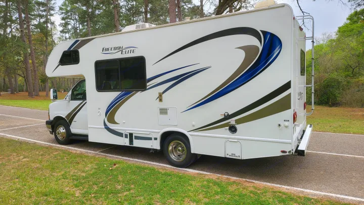 White Class C **rv rental** parked in a scenic park with trees, ready for your next outdoor travel adventure.. Thor 22HE 2019