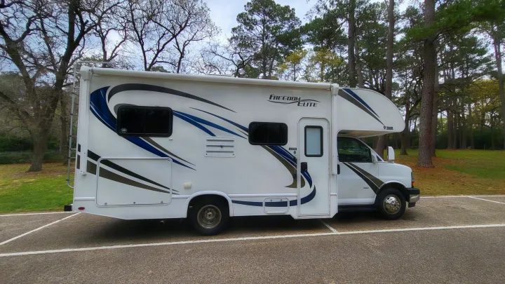 This white Thor Freedom Elite RV rental is parked among trees, perfect for your next motorhome travel or camping adventure.. Thor 22HE 2019