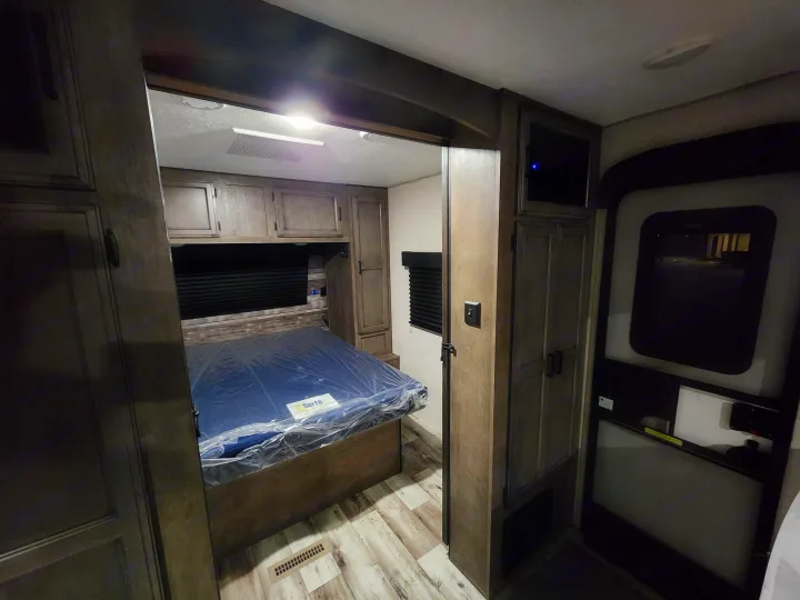 This inviting RV rental bedroom features a new Serta mattress, built-in cabinetry, and wood-look flooring.. Venture Sporttrek 2022