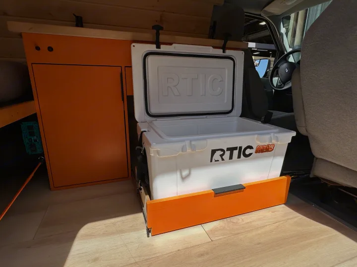 Inside an RV rental: custom orange storage, a sliding RTIC cooler, and light wood-look flooring for adventure.. Ford Extended E350 2011