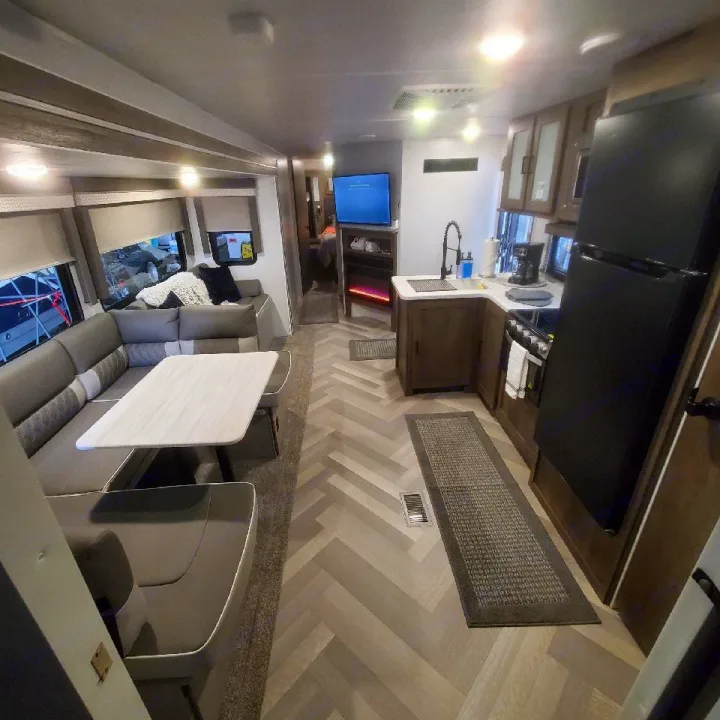 Bright RV rental interior showing a comfortable dinette, modern kitchen, and living space. Ready for your travels!. Forest River Salem 2022