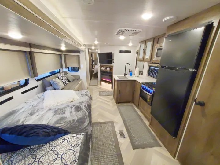 This RV rental showcases a bright, modern interior with a convertible bed, full kitchen, and entertainment area.. Forest River Salem 2022