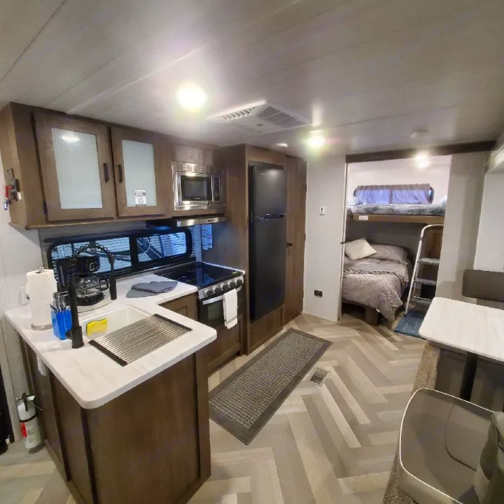 RV rental interior showcasing a well-equipped kitchen, bunk beds, and dining area for your next adventure.. Forest River Salem 2022