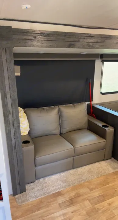 Comfortable two-seater couch with cupholders inside a modern rv rental. This cozy living space is perfect for your home on wheels.. Keystone RV Hideout 2022