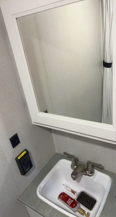 Compact RV rental bathroom featuring a sink, mirror, and essential toiletries.. Keystone RV Hideout 2022