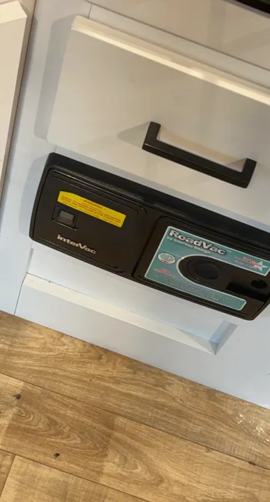 Close-up of an InterVac RoadVac built-in vacuum, essential for easy cleaning in an RV rental interior.. Keystone RV Hideout 2022