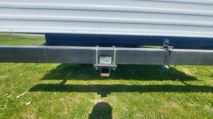 View of an RV rental's black bumper with a bolted-on trailer hitch receiver, essential for towing.. Forest River Wildwood 2020