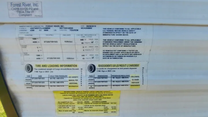 Detailed RV rental vehicle label displaying manufacturing specs, tire information, and cargo capacity data for safe operation.. Forest River Wildwood 2020