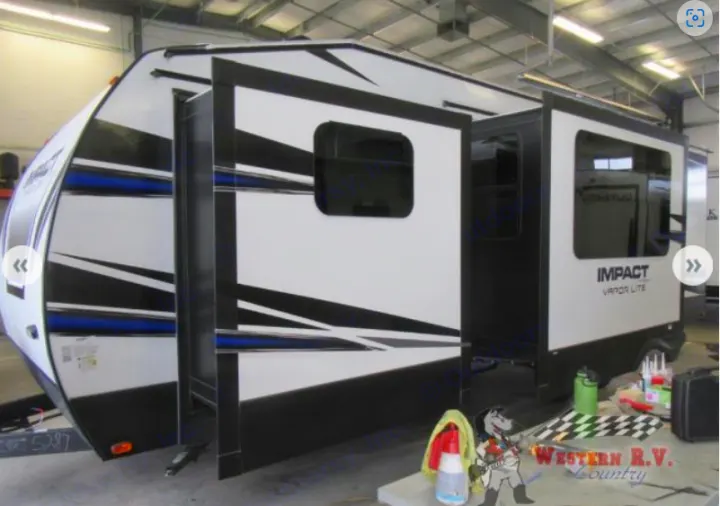 View of a white and black Impact Vapor Lite RV with extended slide-outs, perfect for your next RV rental.. Keystone Impact 2019