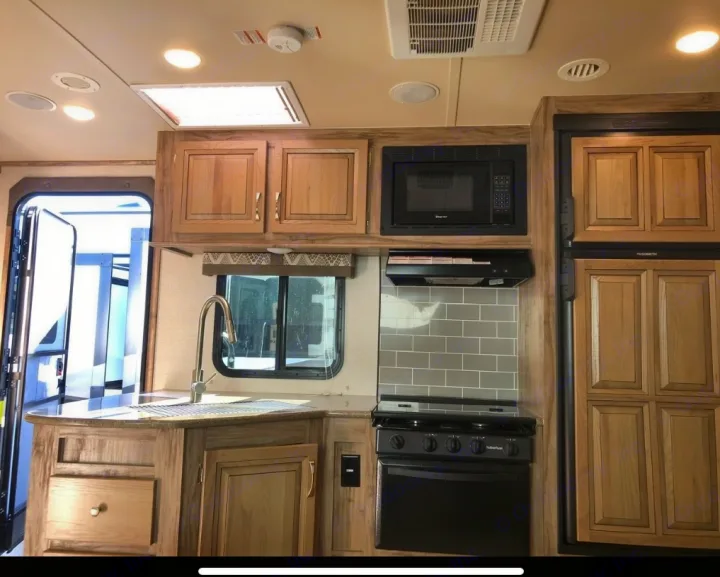 RV rental kitchen interior: modern design with full appliances like microwave, stove, fridge, sink, and cabinets. Ready for your next adventure!. Palomino 240bhs 2018