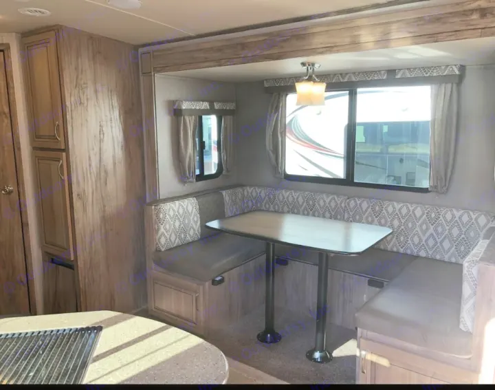 RV rental interior showcasing a comfortable U-shaped dinette with large windows and ample storage cabinets.. Palomino 240bhs 2018