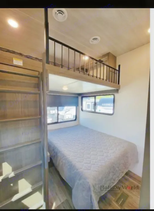 Experience the comfort of this RV rental, featuring a lower bed, ladder access to a loft, and large windows.. Keystone Cougar 2023