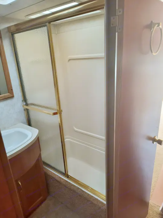 Compact RV rental bathroom: features a shower, sink, and vanity for your travel needs.. Damon Corporation Daybreak 2001
