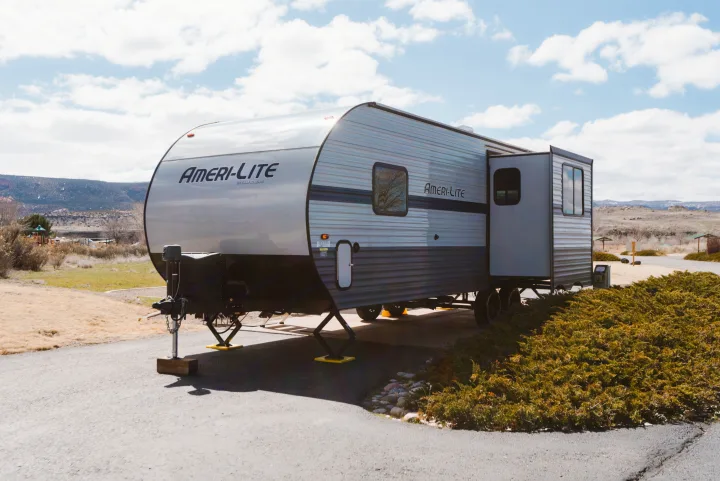 Spacious Ameri-Lite travel trailer RV rental parked at a scenic campsite with mountains in background.. Gulf Stream Ameri-Lite 2021