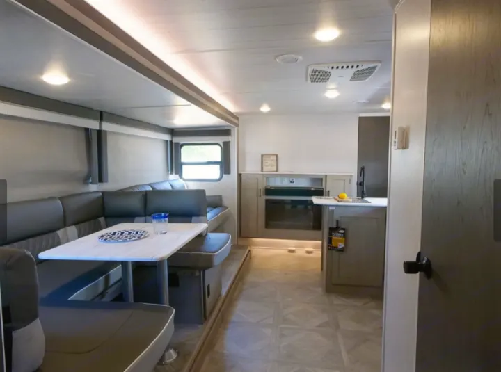 Modern RV rental interior: large dinette seating, well-equipped kitchen area, and bright lighting.. Forest River Forest River 2023