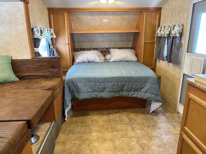 RV rental: Compact interior showing bedroom area with bed, brown sofa for living space, and built-in wood cabinetry. Tiled floor.. KZ Sportsmen 2009