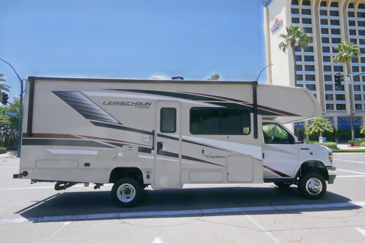 This beige Coachmen Leprechaun RV rental, a Class C motorhome, is parked on a street near Paradise Pier Hotel.. Coachmen Leprechaun 2021