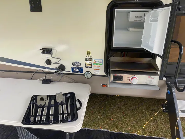 This RV rental boasts an outdoor kitchen with a griddle, mini-fridge, and grilling tools, ideal for camping adventures.. Forest River Salem Hemisphere HL 2021