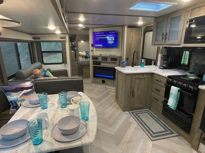 Inside a cozy RV rental: Full kitchen, dining table, and living space. Perfect for glamping trips.. Forest River Salem Hemisphere HL 2021