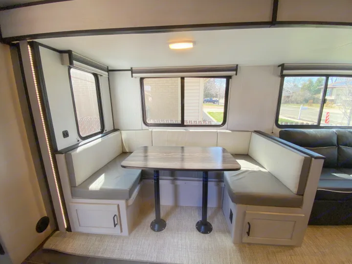 Bright rv rental dinette with comfortable U-booth seating, table, and large windows offering scenic views.. Heartland RVs Mallard 2022