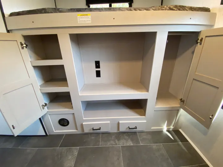 RV rental bunk bed area featuring a built-in storage unit with shelves, open cabinets, and drawers for organization.. Heartland RVs Mallard 2022