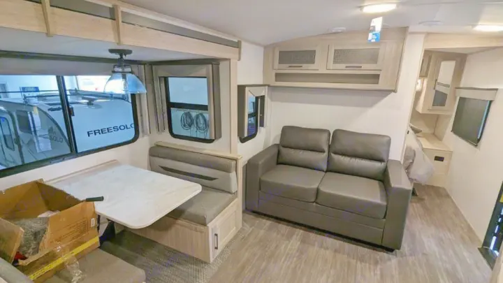 RV rental interior: A modern living space with a dining booth, comfortable sofa, and compact sleeping area.. Twilight RVS Signature 2022
