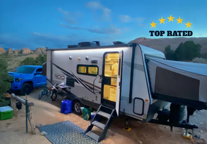 Enjoy a top-rated rv rental experience! This travel trailer is set up for desert camping with a truck, gear, and lights on.. Forest River Rockwood Roo 2021