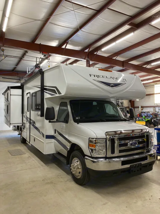 Spacious white Coachmen Freelander Class C motorhome in a well-lit garage, ideal for rv rental.. Coachmen Freelander 2024