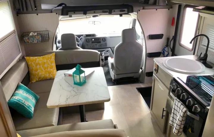 Explore this spacious and modern RV rental interior, featuring a dining booth, kitchen, and front cab for comfortable travel.. Forest River Coachmen Cross Trail XL 2022