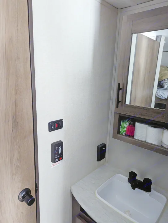 Inside an RV rental: compact bathroom featuring a sink, mirror cabinet, and essential wall controls.. Avenger 26bk 2021
