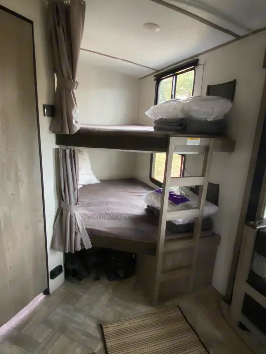 Interior of an RV rental with stacked bunk beds, providing compact sleeping space for travelers.. Keystone Springdale 2021