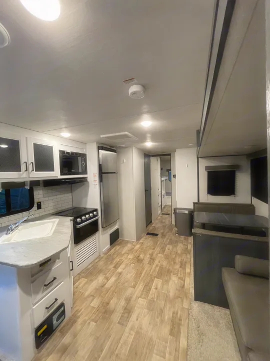 This RV rental features a modern, clean interior with a full kitchen, dinette, and spacious hallway.. Keystone RV Hideout 2022