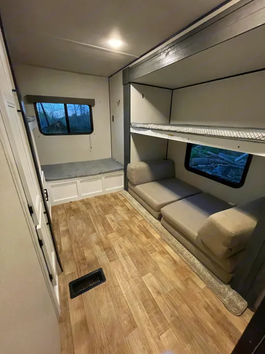 Spacious RV rental bunkhouse features convertible modular sofa, cozy bunk beds, and bench storage.. Keystone RV Hideout 2022