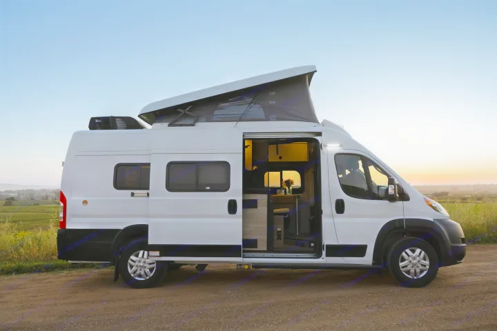 White pop-top RV rental parked on a dirt road at sunset. Its open side door reveals a bright, cozy interior, ready for adventure.. Winnebago Solis 2022
