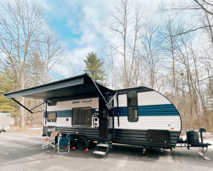 Grey Wolf travel trailer RV rental parked with awning extended, ready for outdoor adventure and camping.. Cherokee MKSE22 2023