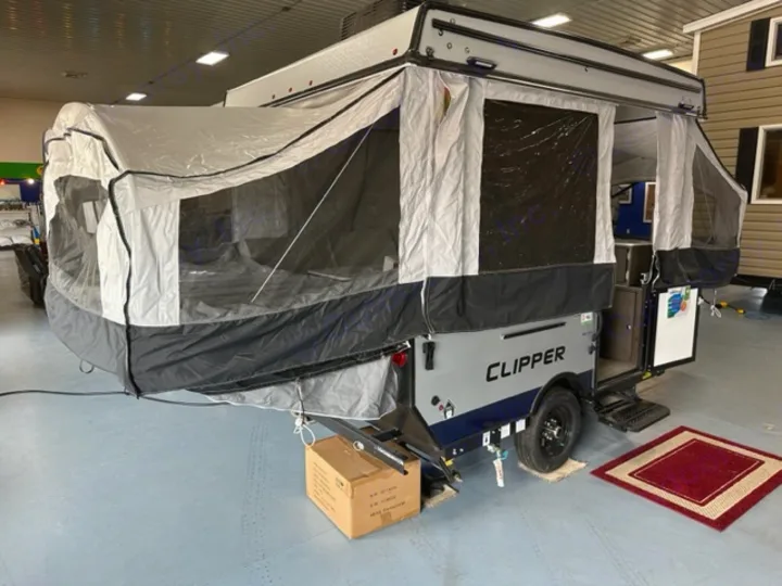 A gray and black Clipper pop-up camper is fully set up indoors, ready for an RV rental.. Coachmen Clipper 806XLS 2022